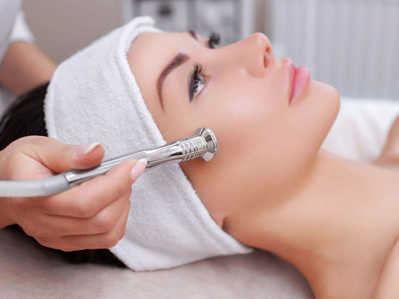 The Cosmetologist Makes the Procedure Microdermabrasion of the Facial Skin of a Beautiful, Young Woman