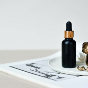 A bottle of serum sitting on top of a white plate.