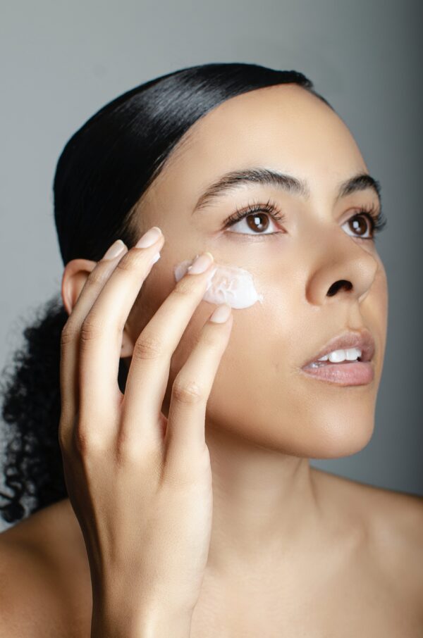 A model applying skincare products on her face